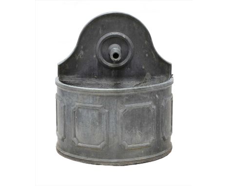 A lead cistern, 20th century, the domed top with a projecting faucet, above a panelled demilune basin, 63cm wide 28cm deep 70