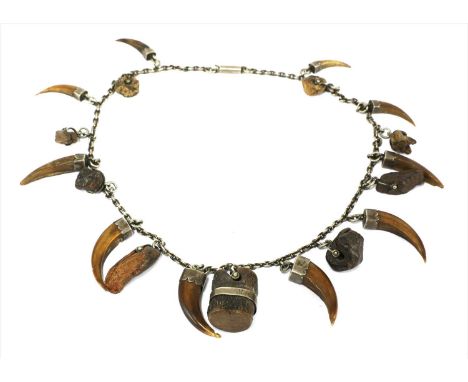 An African witch doctor's necklace, with nineteen hawks' claws of varying sizes and charmed wooden blocks, attached to a chai