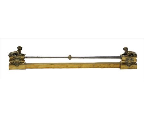A brass fender, 20th century, each end set with a reclining dog above a putto mask, 120cm wide Provenance: Upper Swell Farm, 
