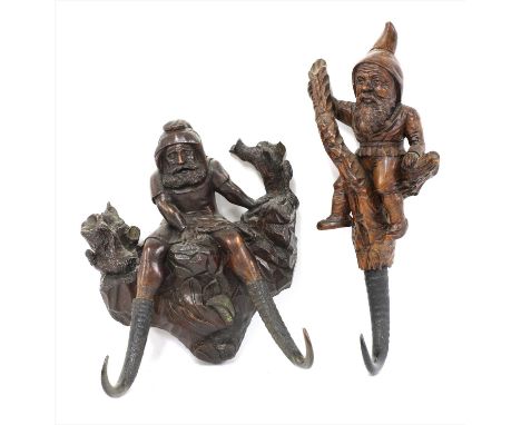 Two Black Forest carved wooden wall hooks , early 20th century, the first a woodsman with double antler hooks, 26cm high, the
