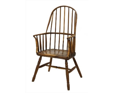 A primitive yew stick back Windsor chair, 18th century, with a substantial seat and ring turned supports united by a knopped 