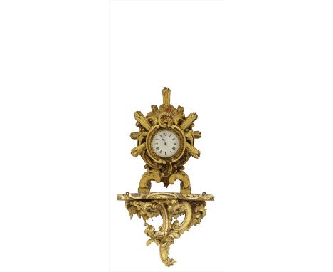 A carved giltwood cased mantel clock, the enamel dial set with Roman numerals and inscribed 'Harrods', 38cm high on a scrolli
