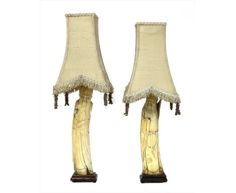 A pair of Chinese ivory tusk figures , 17th century, carved as immortals, now mounted as table lamp s, each on an hardwood st