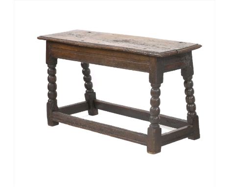 An oak bench, 17th century, with a plank top on bobbin-turned splay legs and all-round stretchers, 108cm wide 35cm deep 55cm 