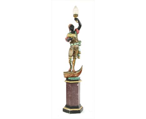 A carved and polychrome painted blackmoor lamp , 20th century, holding aloft a torch and standing on the prow of a gondola, o
