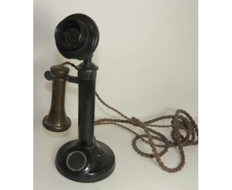 A candlestick telephone with original wire, original brown earpiece and black metal base,  32cms high ++some wear but no seri