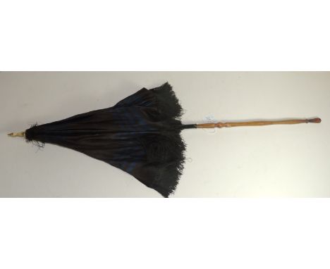 A Victorian parasol with turned bone finial, folding wood handle and blue lined brown silk canopy with fringed edge