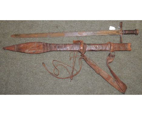 A Sudanese Kaskara sword having leather bound grip, metal cross guard, long double edged blade with simple decoration and sym