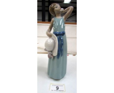 A Lladro figurine of a girl holding a hat