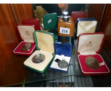 A quantity of commemorative coins and a hip flask