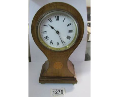 A mahogany inlaid Edwardian balloon clock, spring ok but wound to limit