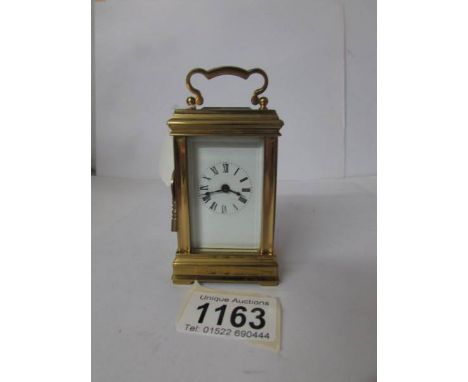 A miniature brass carriage clock with key