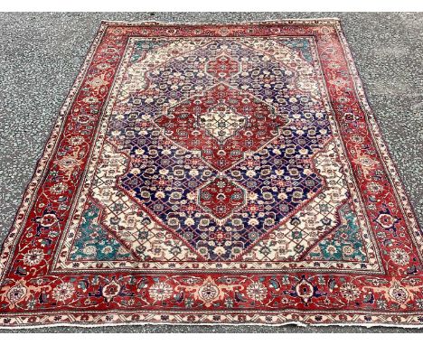 TABRIZ RUG, blue and red ground with traditional central diamond motif and wide border, 290 x 200cms