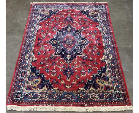 LARGE EASTERN STYLE WOOLEN RUG, traditional style central medallion, red and blue ground, repeating pattern, triple bordered 