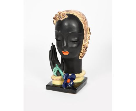 A Goldscheider Pottery bust of a woman, freestanding bust, her hand raised and releasing a blue flower stem, glazed in colour