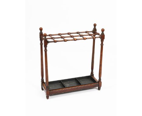 A mahogany stick stand in the manner of Liberty &amp; Co,  rectangular section, with turned uprights, and dowel top, with pai