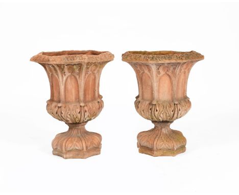 A pair of terracotta garden urns in the manner of Royal Doulton,  octagonal section, each cast with arch panels to the body, 