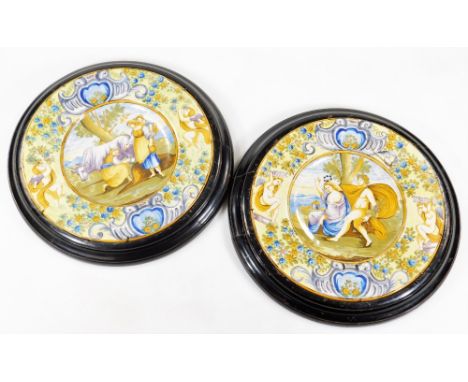 A pair of  Italian Maiolica wall plaques, each of circular form, the first centred with figures and cattle, the second a clas