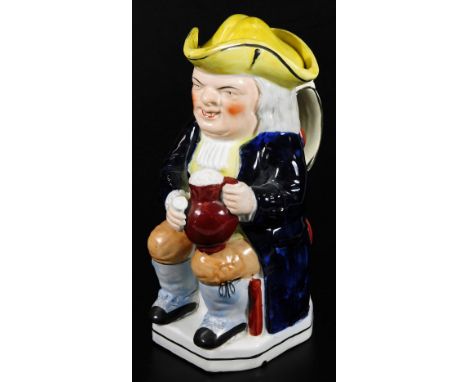A mid 19thC Staffordshire pottery Toby jug and cover, decorated with a bright yellow triangular hat and cover. 25cm H.