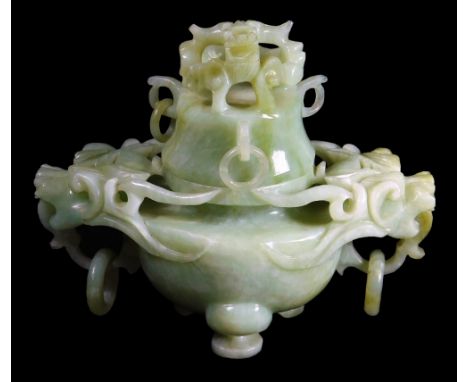 A green jade decorated koro and cover, carved with stylized dragons, with loose rings, the cover of domed form with pierced d