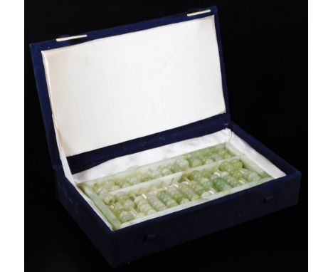A polished green jade coloured abacus, of rectangular form, set with compressed beads, 25cm W. (boxed)