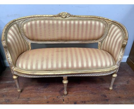 A reproduction Louis XVI style parlour suite consisting of two chairs and a sofa finished in a pink and gold striped fabric w