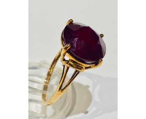 A 9ct yellow gold dress ring, set with a large round cut ruby, measuring 10mm in diameter, ring weighs 4.6 grams, finger size