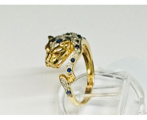 An 18ct yellow gold dress ring, Cartier style in the shape of a leopard, with sapphires, diamonds and ruby eyes, weighs 4.9 g