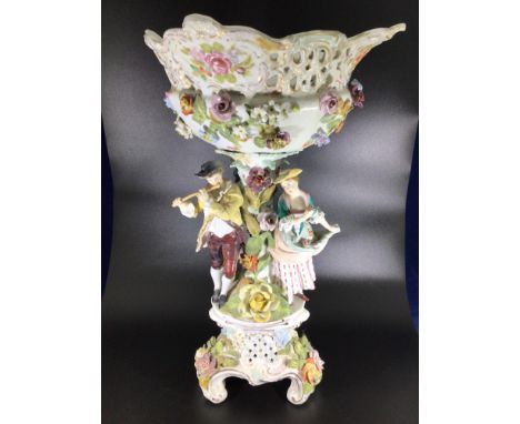 A late 19th / early 20th century large ceramic Dresden figural and floral encrusted comport, decorated with a man playing a p