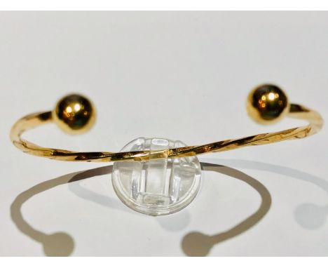 A 9ct yellow gold Torque bangle of twisted design, weighing 11.1 grams. 