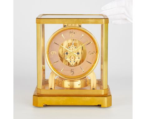 Jaeger LeCoultre, Switzerland. Atmos mantel clock. Round dial with gold Arabic and stroke numerals. In a glass case with gilt