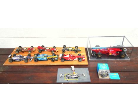 Model of a Ferrari F1 car, W.36.5cm, in a glass and simulated carbon fibre case; 6 other models of F1 cars, mounted on 2 pine