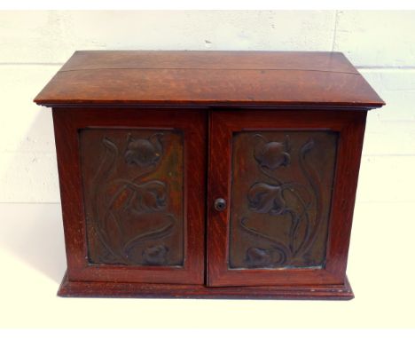 Good Art Nouveau oak smoker's cabinet with 2 floral embossed copper panelled doors enclosing a secret central panel fall door