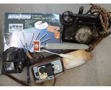 An Ericsson Bakelite telephone, a cine camera, a Ful-Vue camera and light meter, a tripod and a pen set