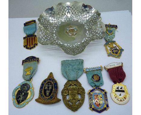 A collection of Masonic enamel badges and a plated tray