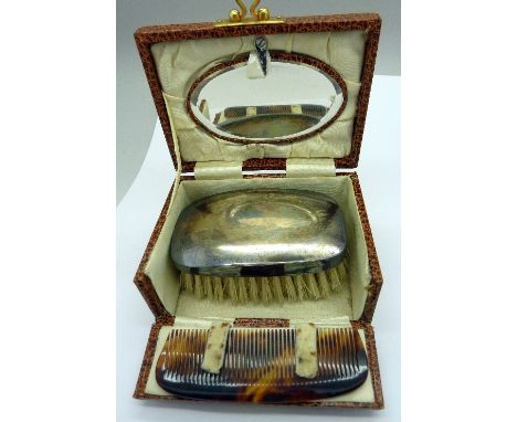 A silver backed brush with a mirror and comb, cased