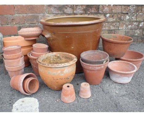 A GROUP OF TERRACOTTA FLOWERPOTS a drilled old bread pancheon, and a hand fork