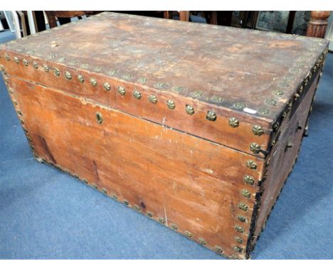 A LARGE 19TH CENTURY TRUNK WITH BRASS ROSETTE STUDS (pine, stripped of its cloth covering, carrying handles missing) 94cm wid