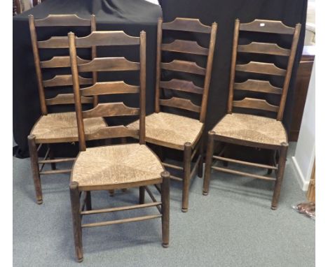 A SET OF FOUR ARTS AND CRAFTS RUSH SEATED LADDER BACK CHAIRS each 107cm high x 47cm wide (4)