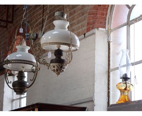 TWO VICTORIAN HANGING OIL LAMPS with white glass shades and an amber glass oil lamp (3). Provenance: The Estate of the late J