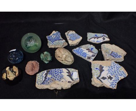 A COLLECTION OF PERSIAN TILE FRAGMENTS, A CARVED SCARAB BEETLE a Caithness paperweight, and other items