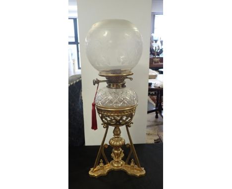 A 19TH CENTURY BRASS TABLE OIL LAMP OF 'GOTHIC' DESIGN with Wright &amp; Butler Duplex burner, lozenge cut reservoir, on angl