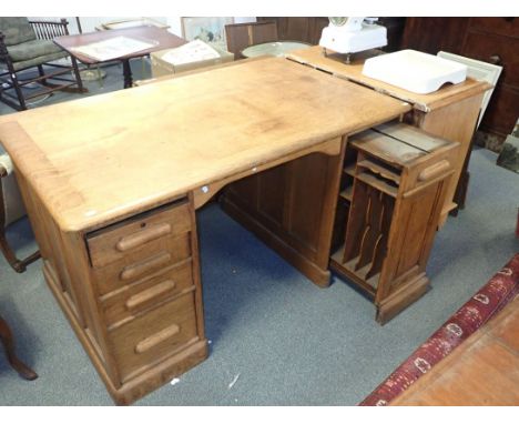 AN EDWARDIAN LIGHT OAK OFFICE DESK the right-hand pedestal pulling out fully and fitted with pigeon holes 135cm wide