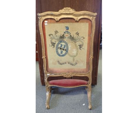 A 19TH CENTURY GILT WOOD FIRE SCREEN with armorial wool work panel 55cm wide (frame in distressed condition)