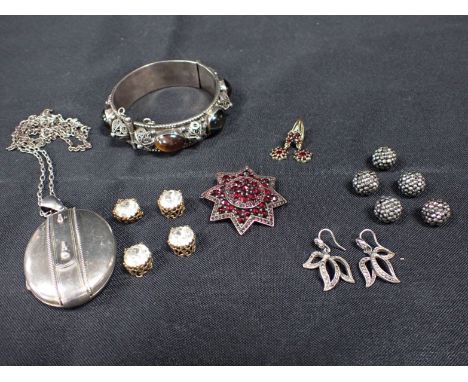 A WHITE METAL AND TIGER'S EYE BANGLE with white metal filigree decoration, a Victorian silver locket with belt detail, a star