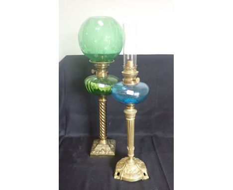 A 19TH CENTURY BRASS TABLE OIL LAMP with green glass reservoir, on spiralled column and square base, with an etched green gla