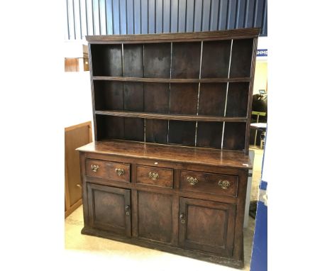 An 18th Century oak and elm dresser, the two tier boarded plate rack with reeded cornice over three drawers and two cupboard 