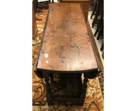 An 18th Century oak oval gate-leg drop-leaf dining table, the single end drawer with brass drop handle and flower head back p