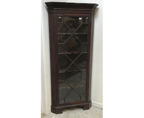 A 19th Century mahogany freestanding corner cabinet, the molded cornice with dentil frieze above an astragal glazed door encl