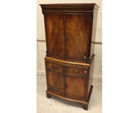 A Bevan Funnell Reprodux mahogany serpentine fronted cocktail cabinet with two doors over  a slide, two drawers and two furth